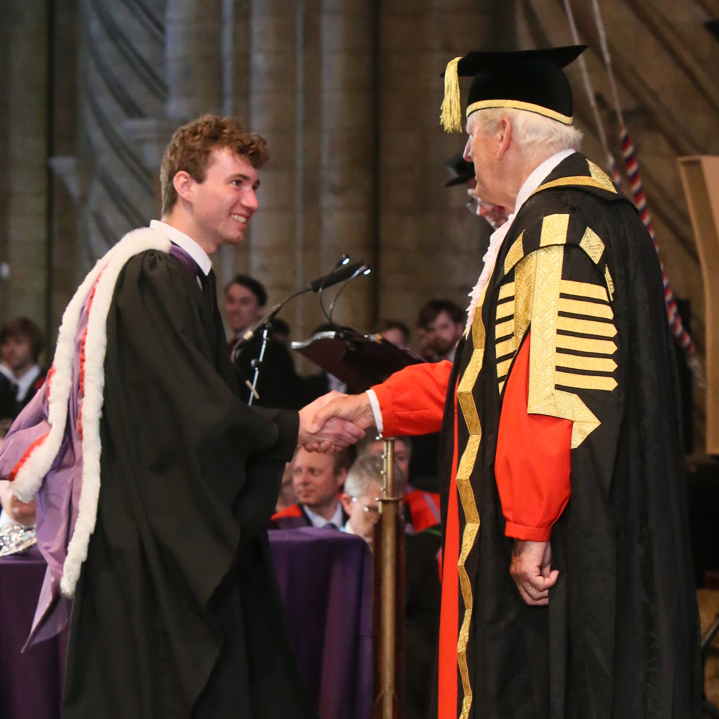 Me shaking hands with an important-looking official in ceremonial dress during my graduation
