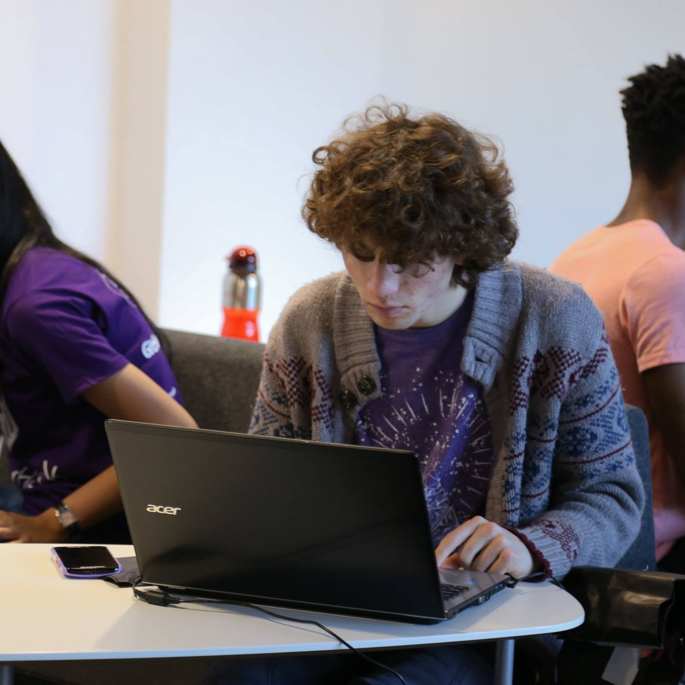 Me as a floppy-haired student sitting in front of my laptop during a Hackathon